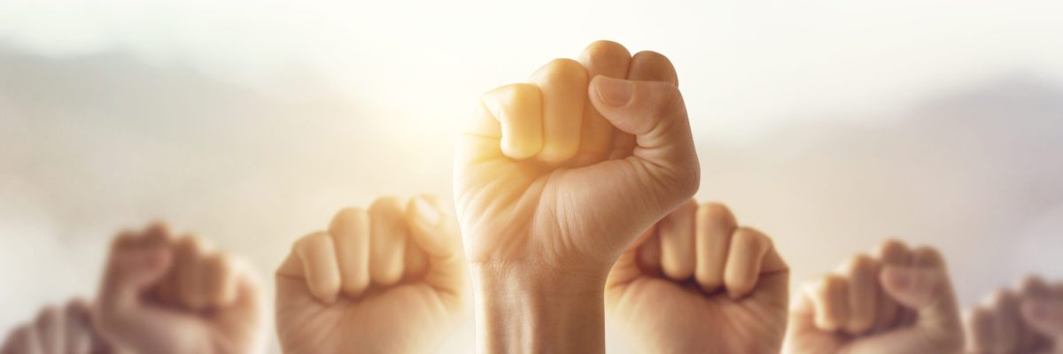 People raised fist air fighting for their rights with sunlight e
