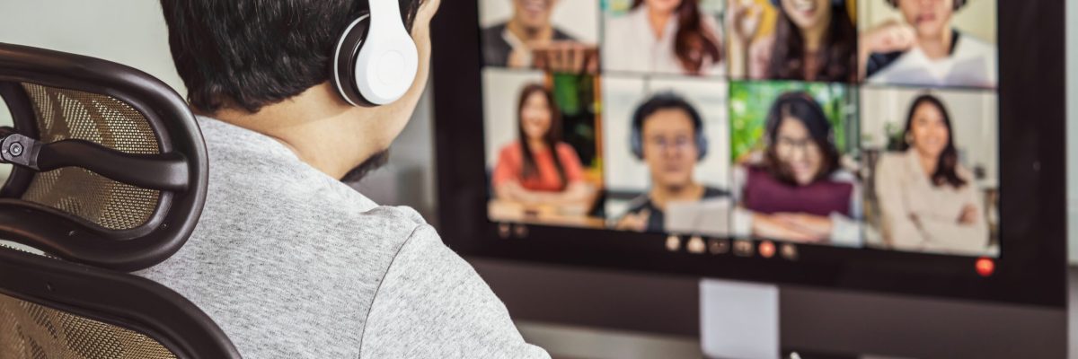 Rear view of Asian man working and online meeting via video conference with colleague and team building when Covid-19 pandemic, Coronavirus outbreak, education and Social distancing,new normal concept