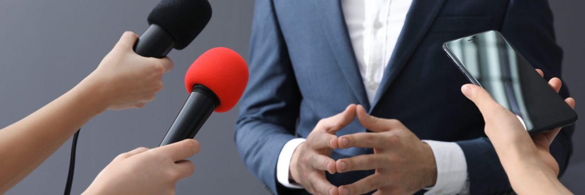 Professional journalists interviewing businessman on grey background, closeup